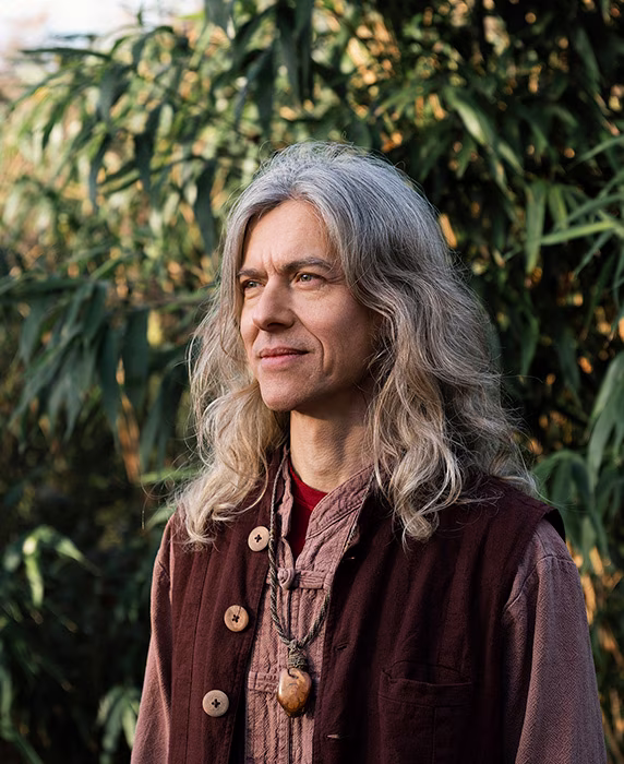 Halbprofil vor Blättern von Frank Ellert, Gründer von Qi-Hypnosia®Mentoring